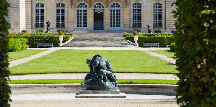 Rodin Museum garden with sculpture and historic building in Paris.
