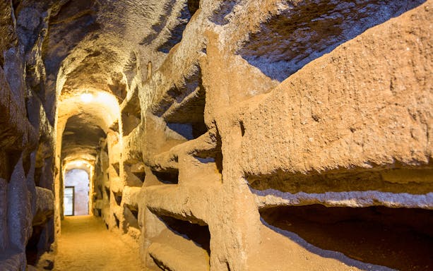 Catacombs corridor with stone niches in Rome, Italy.