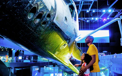 Family observing Atlantis Shuttle at Kennedy Space Center.