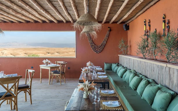 Dining area with desert view at Les Terrasses d'Agafay camp, Morocco.