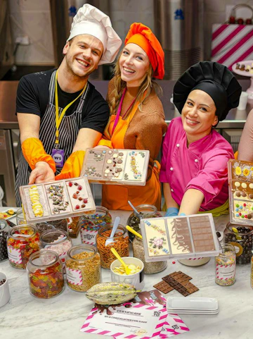 Participants in Vienna chocolate workshop displaying decorated chocolate bars.