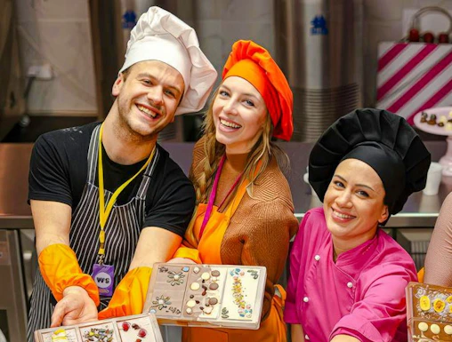 Participants in Vienna chocolate workshop displaying decorated chocolate bars.