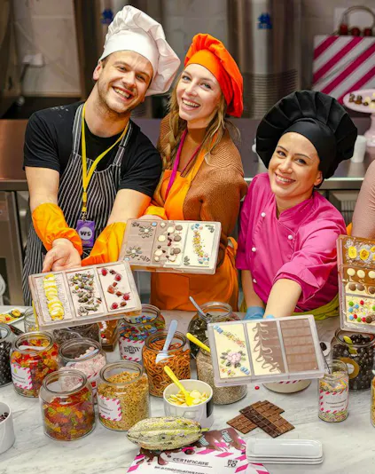 Participants in Vienna chocolate workshop displaying decorated chocolate bars.