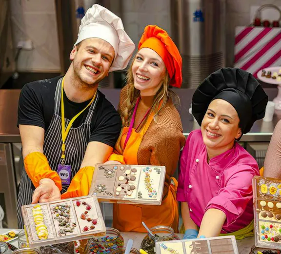 Participants in Vienna chocolate workshop displaying decorated chocolate bars.