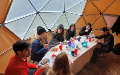Trekking group enjoying a meal inside a dome during Esmeralda Lake hike.