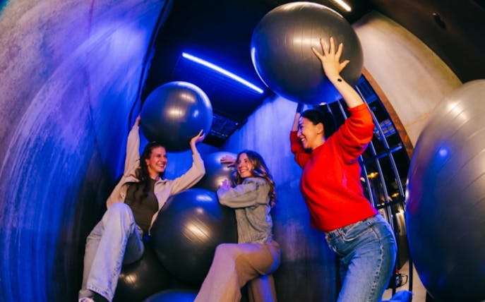 Visitors enjoying an interactive game with large balls at Prison Island Perth.
