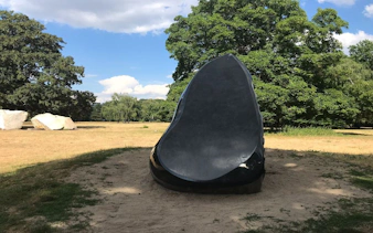Sculpture in Berlin's Tiergarten park surrounded by trees and open field.