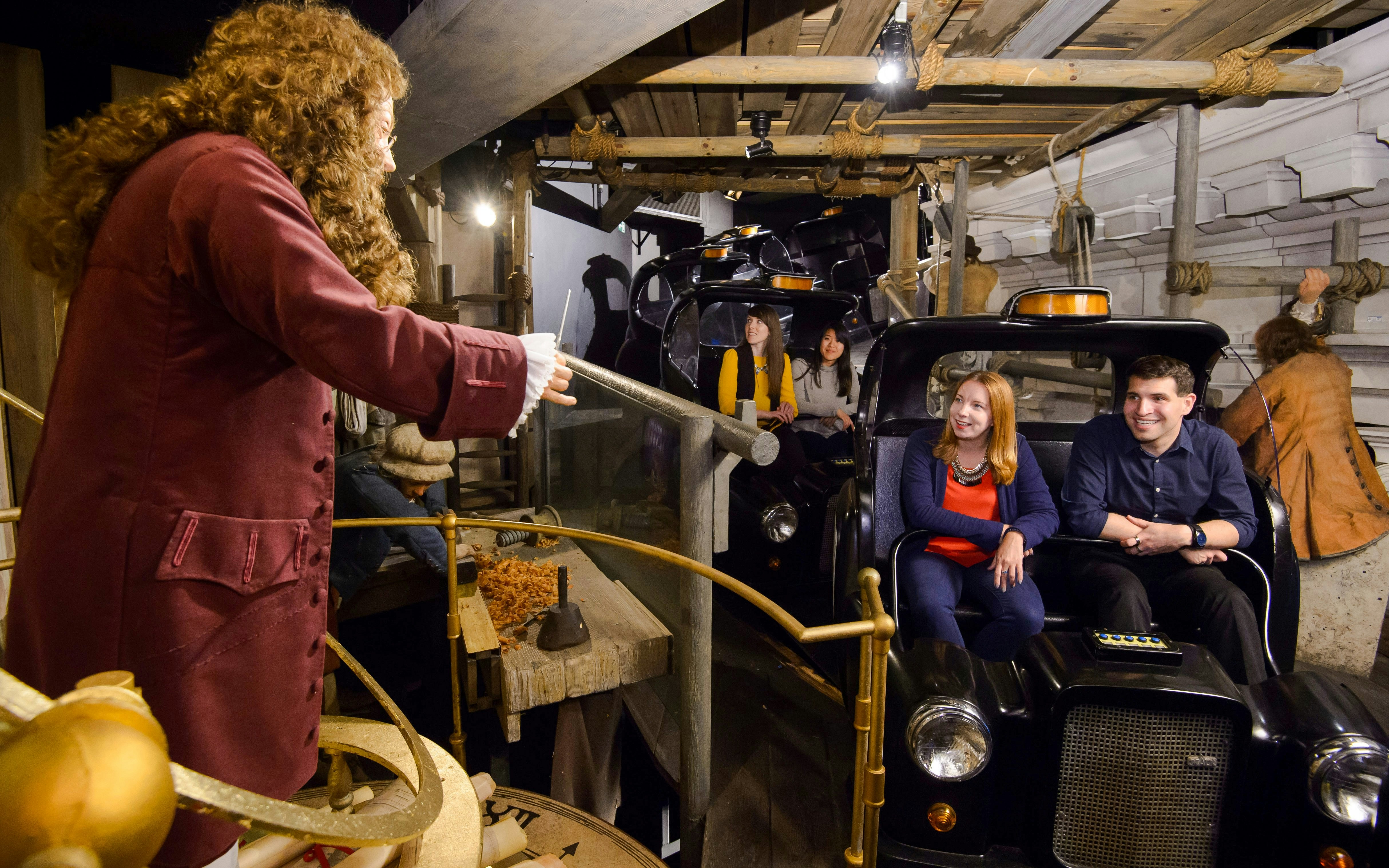 Visitors on a ride at Madame Tussauds London, featuring historical figures and scenes.