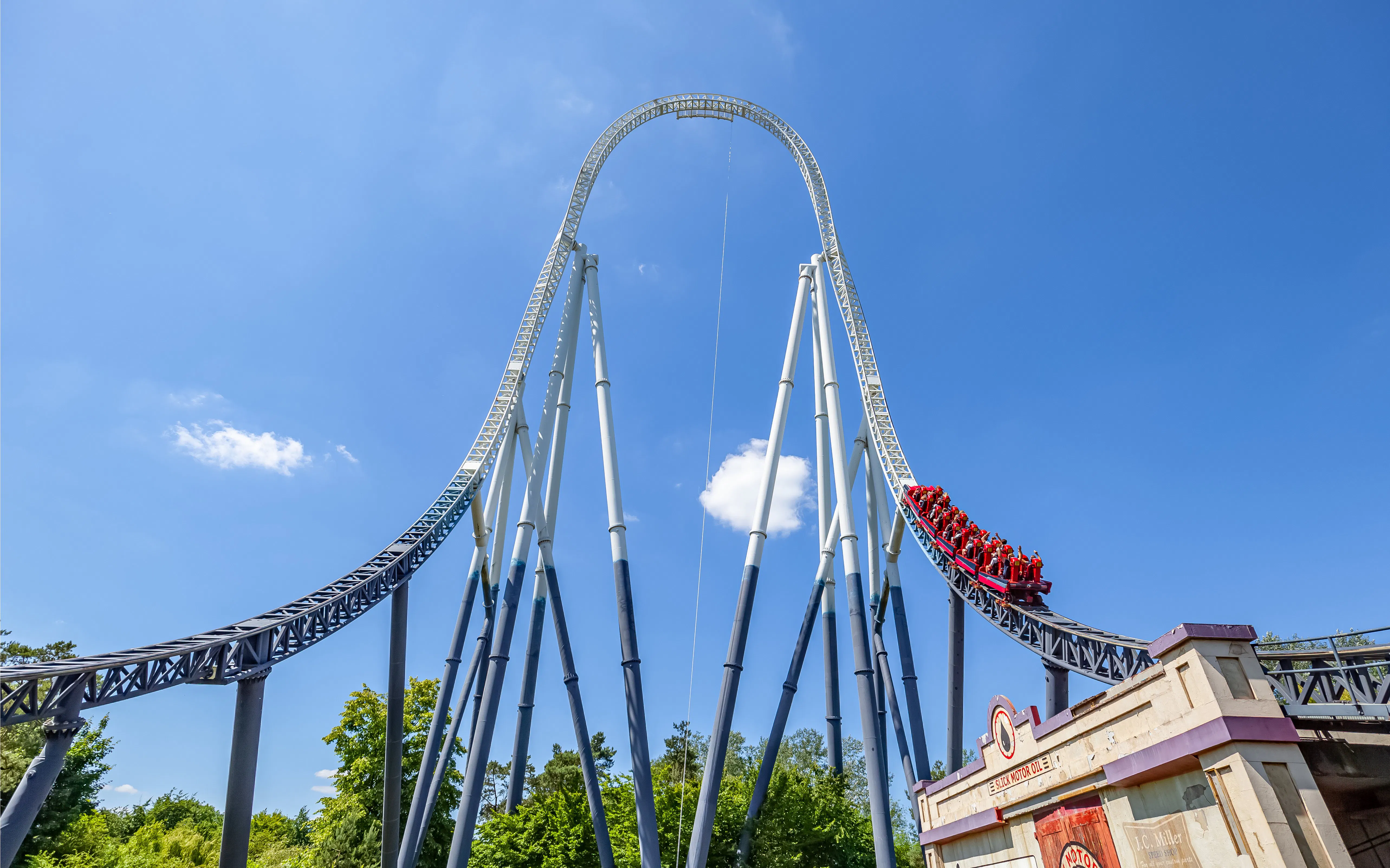 Roller coaster at Thorpe Park with riders descending a steep track.