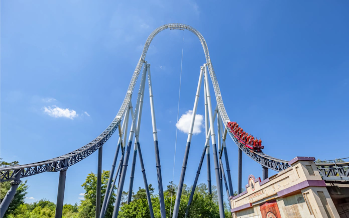 Roller coaster at Thorpe Park with riders descending a steep track.