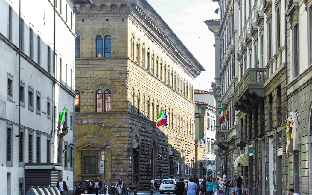 Palazzo Medici Riccardi street view with Italian flags in Florence, Italy.