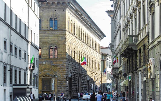 Palazzo Medici Riccardi street view with Italian flags in Florence, Italy.