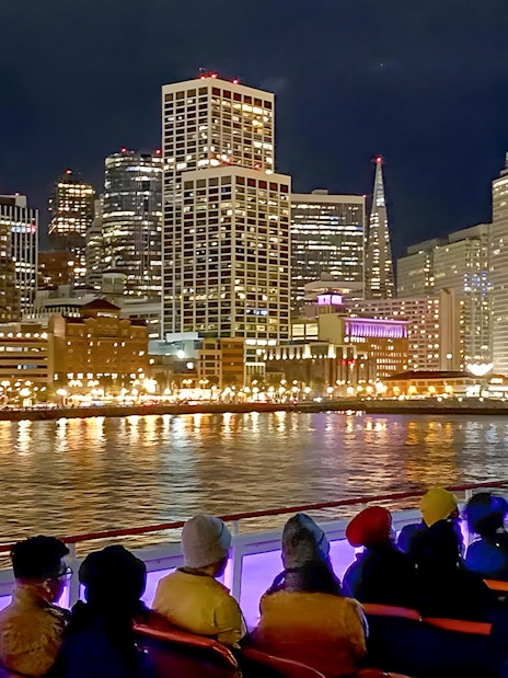 Guests on deck viewing San Francisco skyline during California sunset cruise.