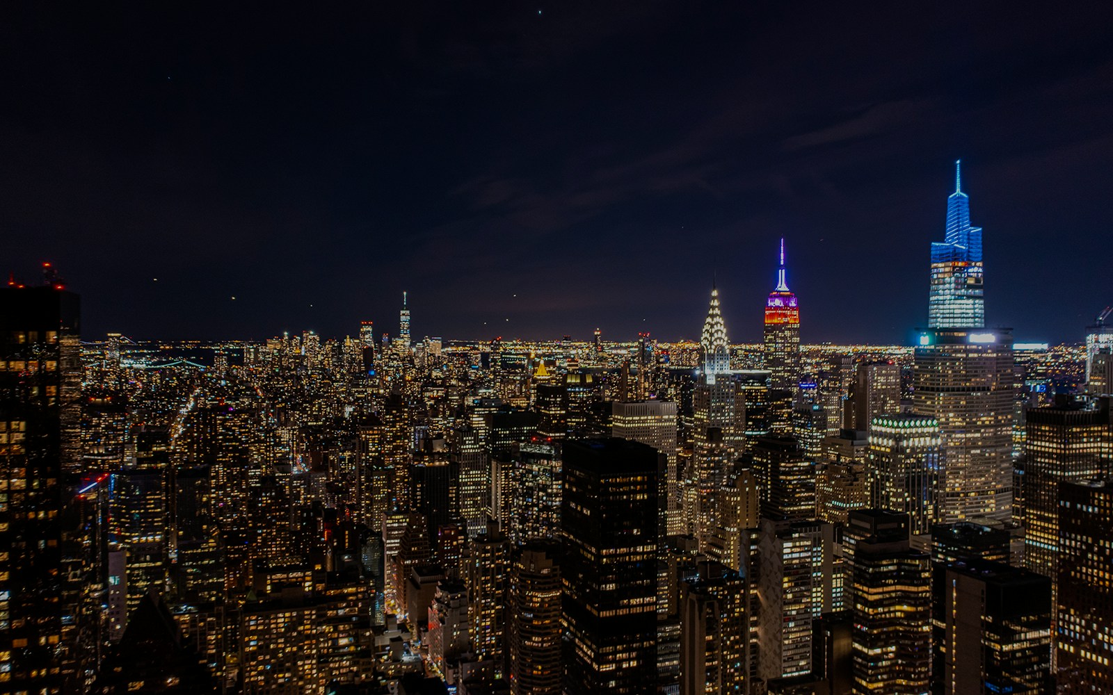 SUMMIT One Vanderbilt illuminated at night with city skyline views, New York City.