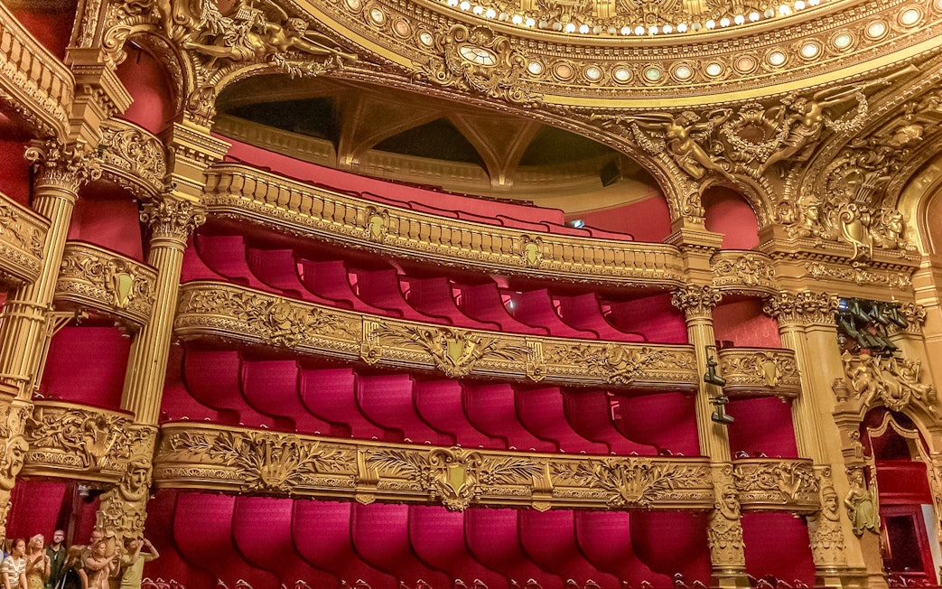 Ornate balconies and red velvet seats in the auditorium of Opera Garnier, Paris.