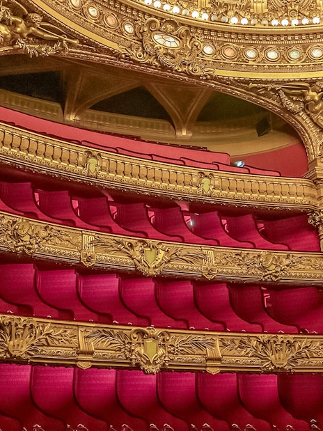 Ornate balconies and red velvet seats in the auditorium of Opera Garnier, Paris.