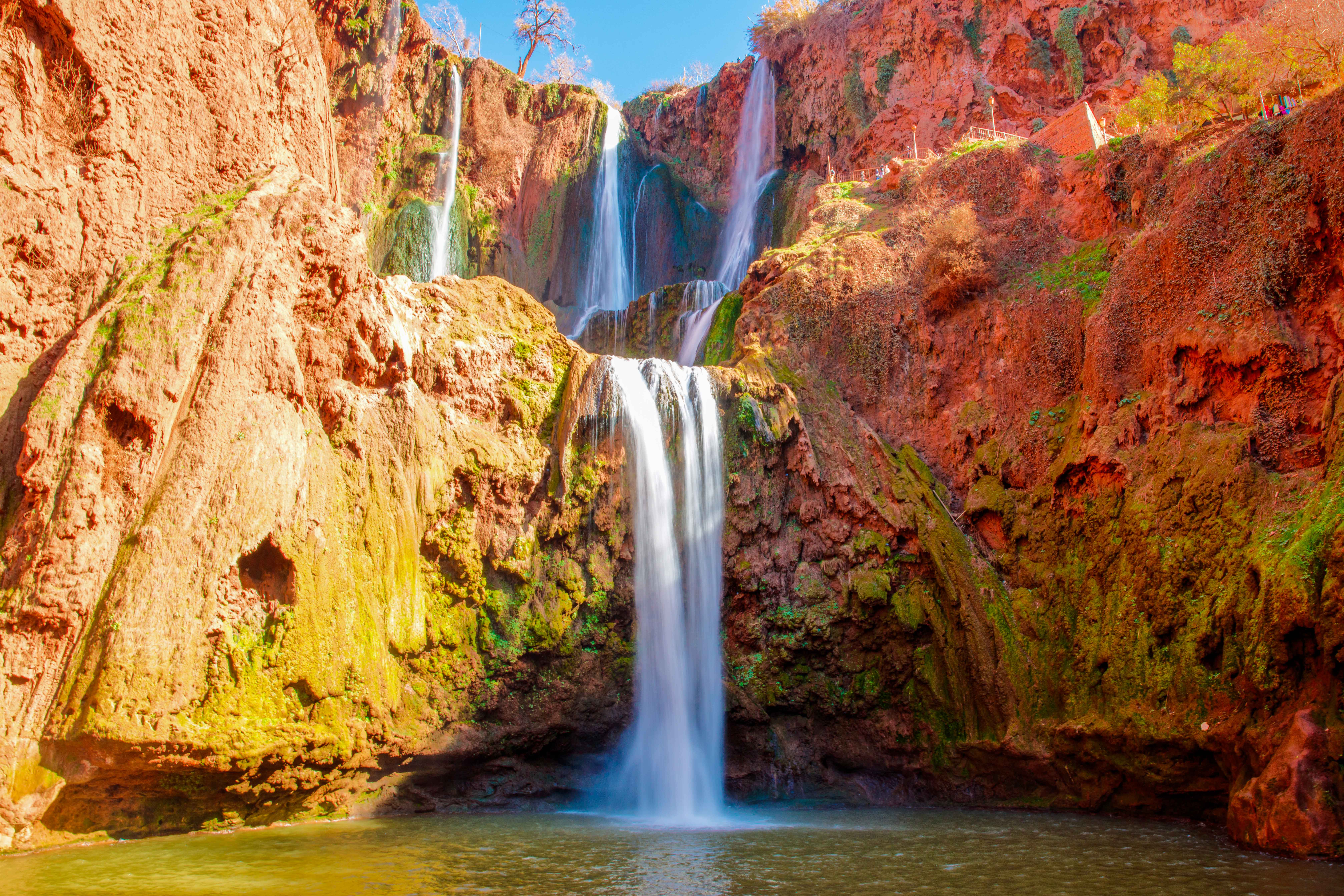 Ouzoud Falls cascading over red rock cliffs in Morocco.