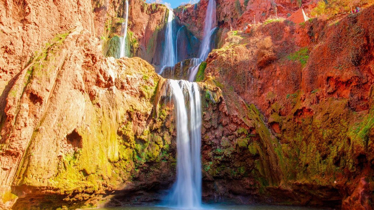 Ouzoud Falls cascading over red rock cliffs in Morocco.