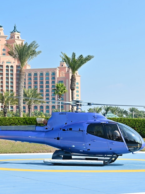 Helicopter on helipad with Atlantis, The Palm hotel in Dubai background.