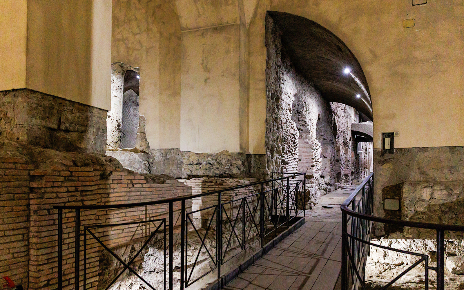 Neapolis Sotterrata ancient stone walls and arches in underground passage.