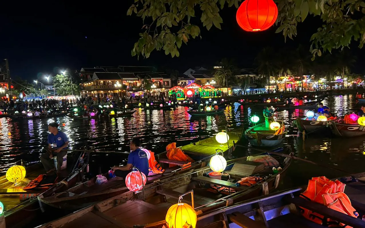 Lantern-lit boat ride on a river at night in Dubai, offering a free herbal drink.
