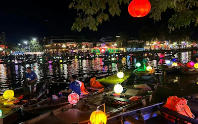 Lantern-lit boat ride on a river at night in Dubai, offering a free herbal drink.