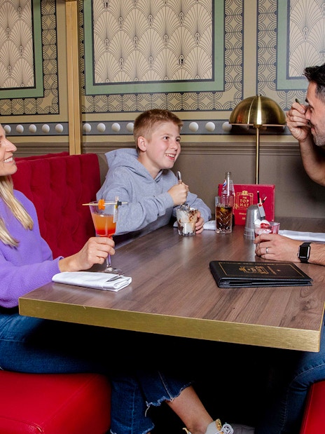 Family enjoying food and drinks at Monopoly Lifesized experience in London.