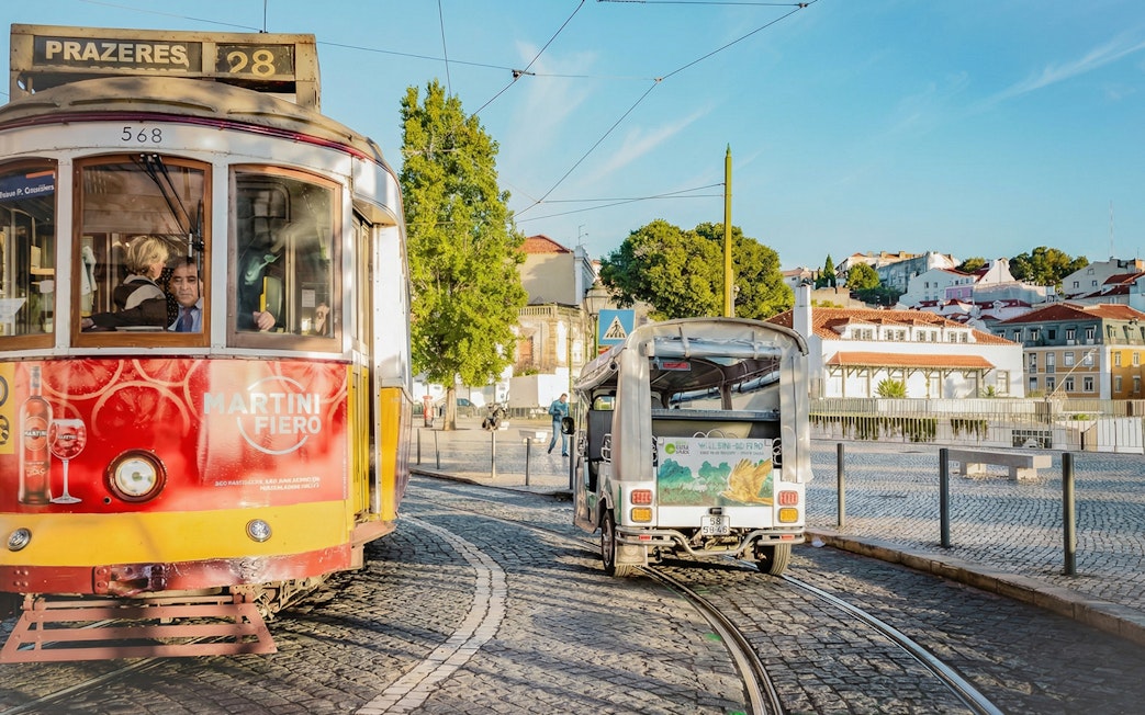 Tuk-Tuk and Tram 28 on Lisbon street, showcasing eco tour route.