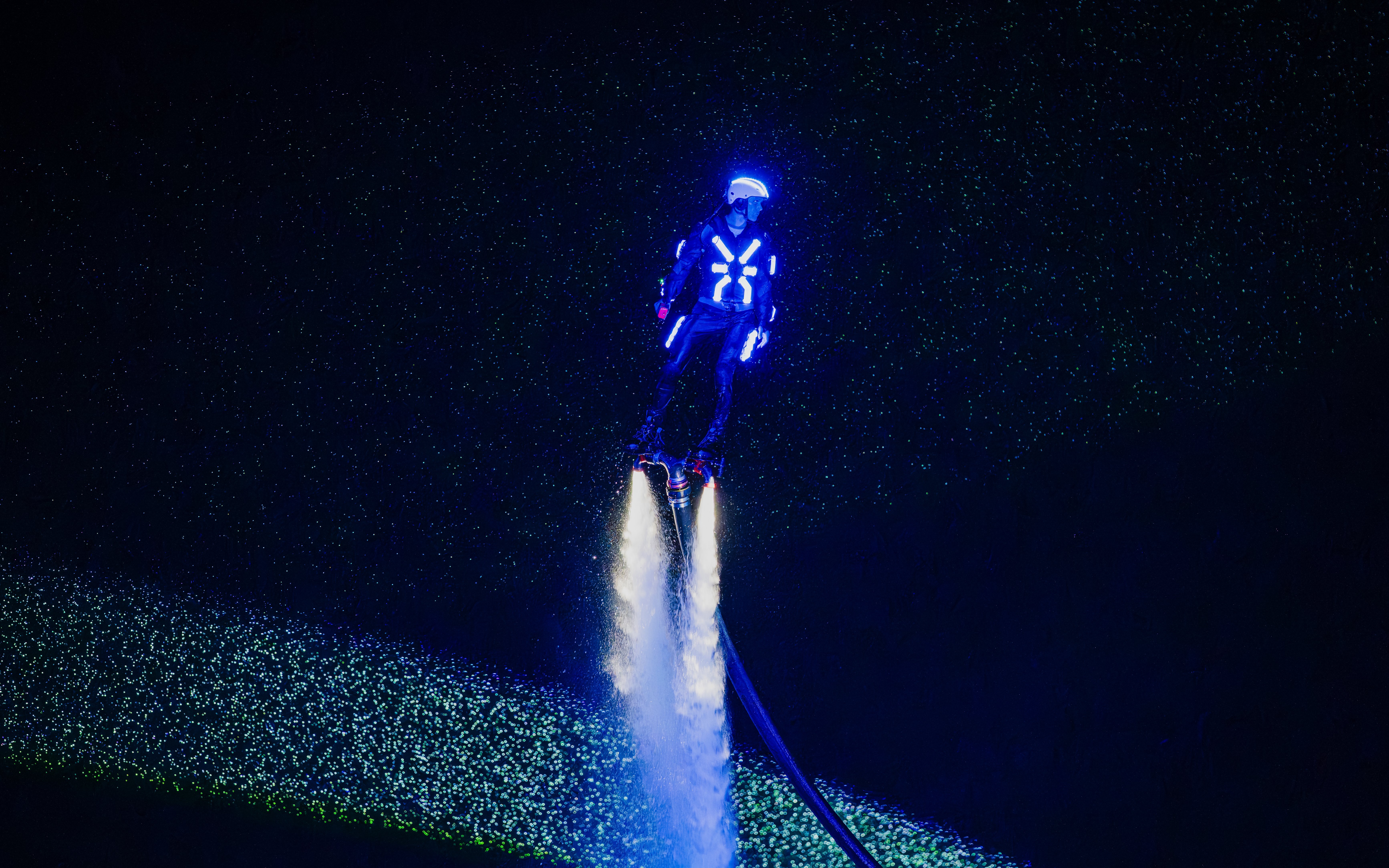 Person flyboarding with neon lights at Symphony of the Sea show.