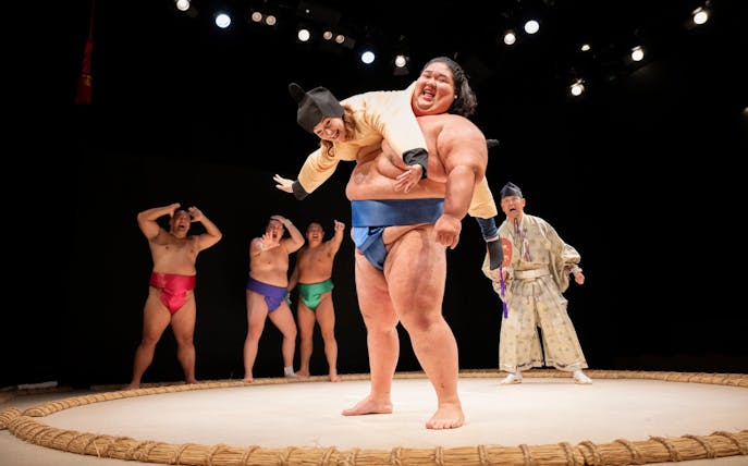 Sumo wrestler lifting performer during show at Hirakuza Ginza, Tokyo.
