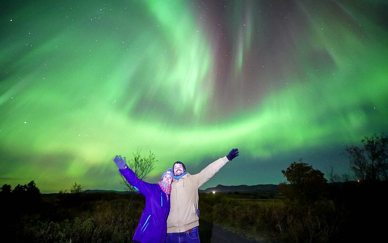 Guests under northern lights on Premium Northern Lights Super Jeep Tour.