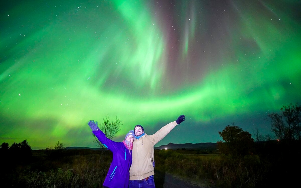 Guests under northern lights on Premium Northern Lights Super Jeep Tour.