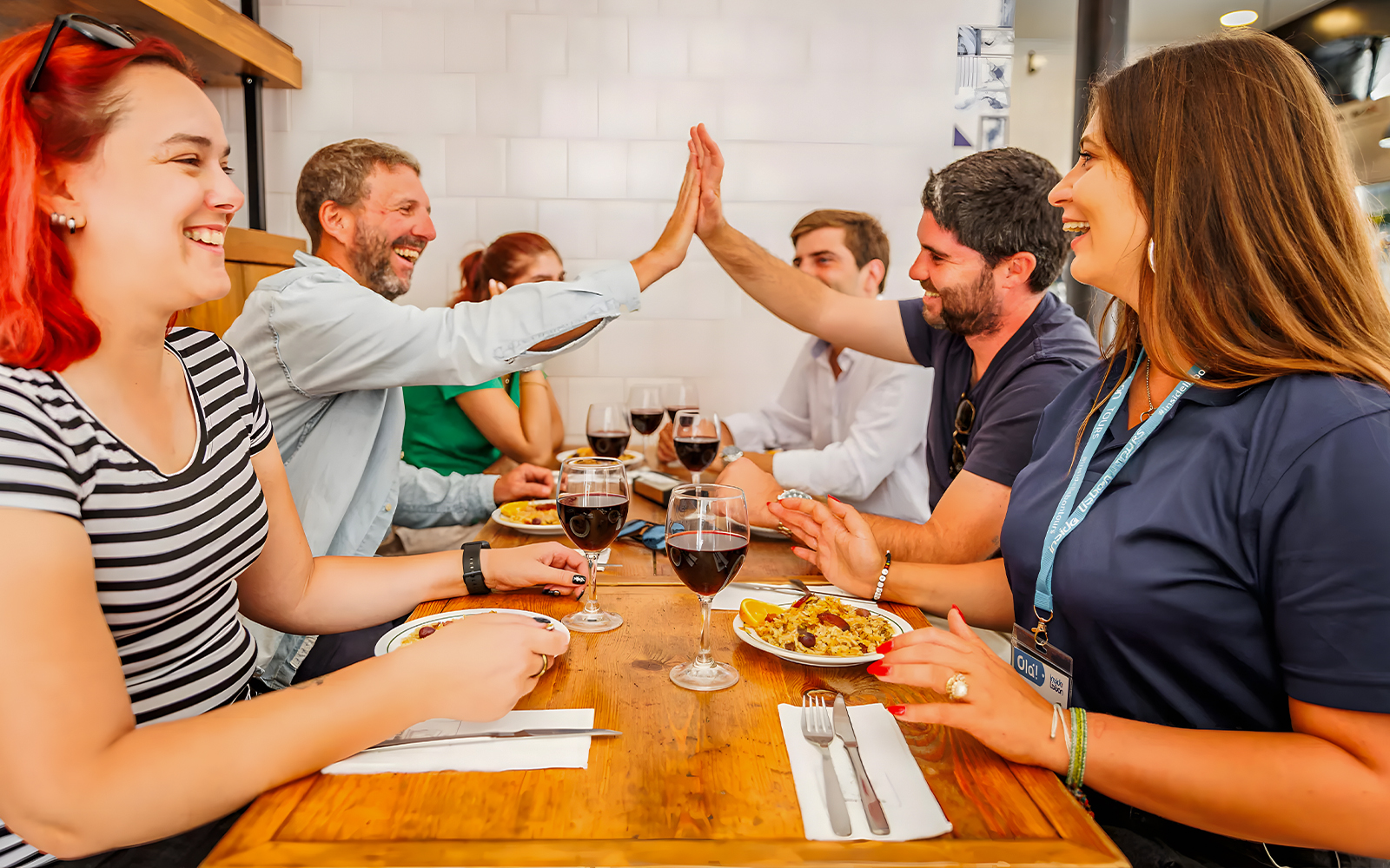 Tourists enjoying food and drinks with a guide at a Lisbon restaurant during a Baixa food walk.