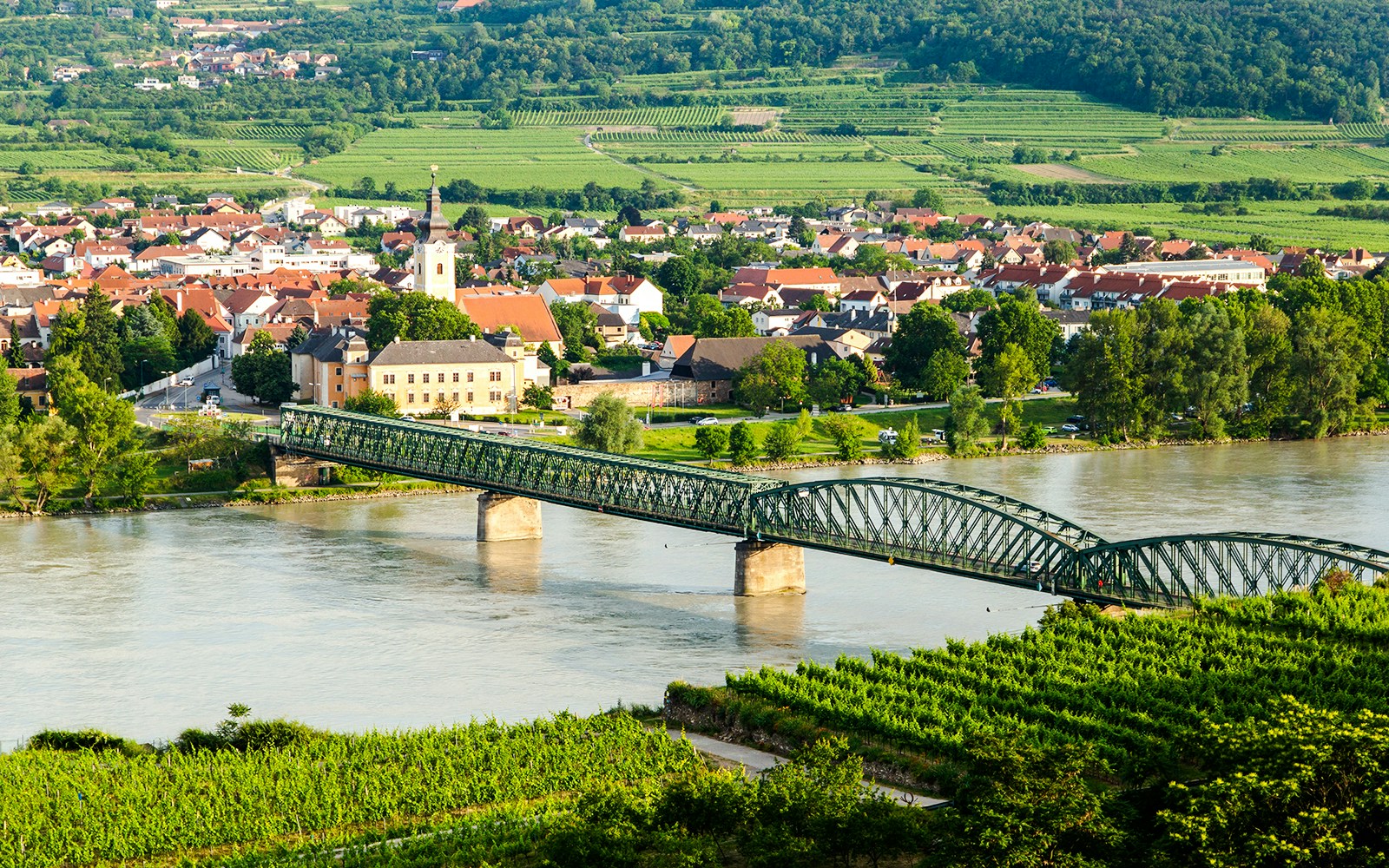Bridge over the Danube River with the town of Mautern and vineyards in the background.