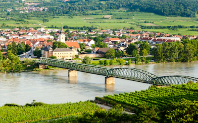 Bridge over the Danube River with the town of Mautern and vineyards in the background.