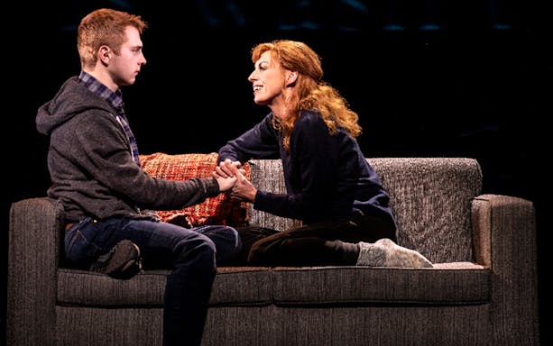 Two actors on a couch in a scene from Dear Evan Hansen musical.