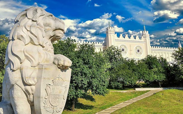 Lion statue in front of Lublin Castle, Poland, on a sunny day.