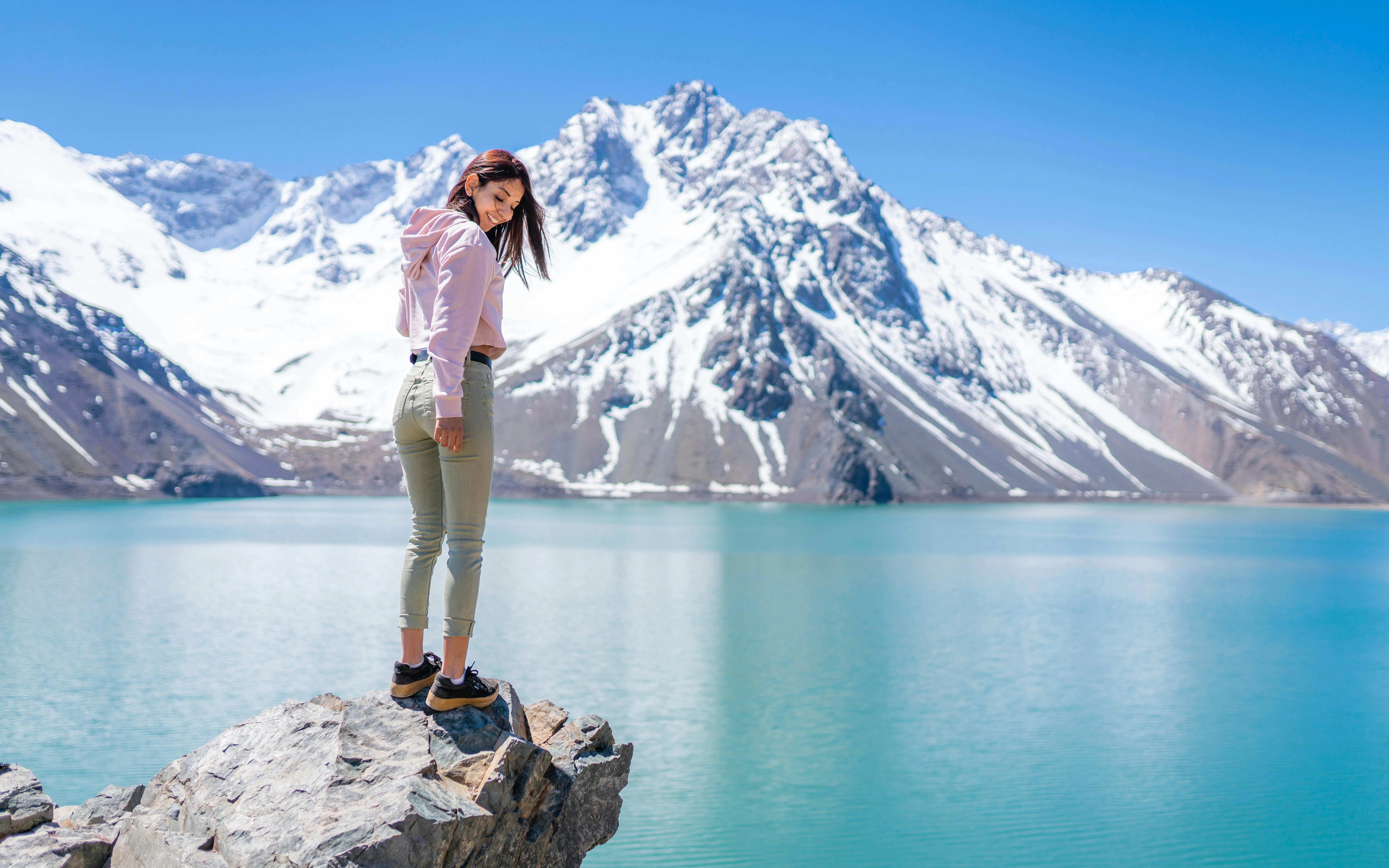 Girl enjoying mountain and turquoise water views at Embalse del Yeso, Chile.