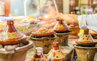 Tagines cooking at a street food stall in Jema el Fna, Marrakesh.