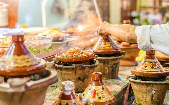 Tagines cooking at a street food stall in Jema el Fna, Marrakesh.