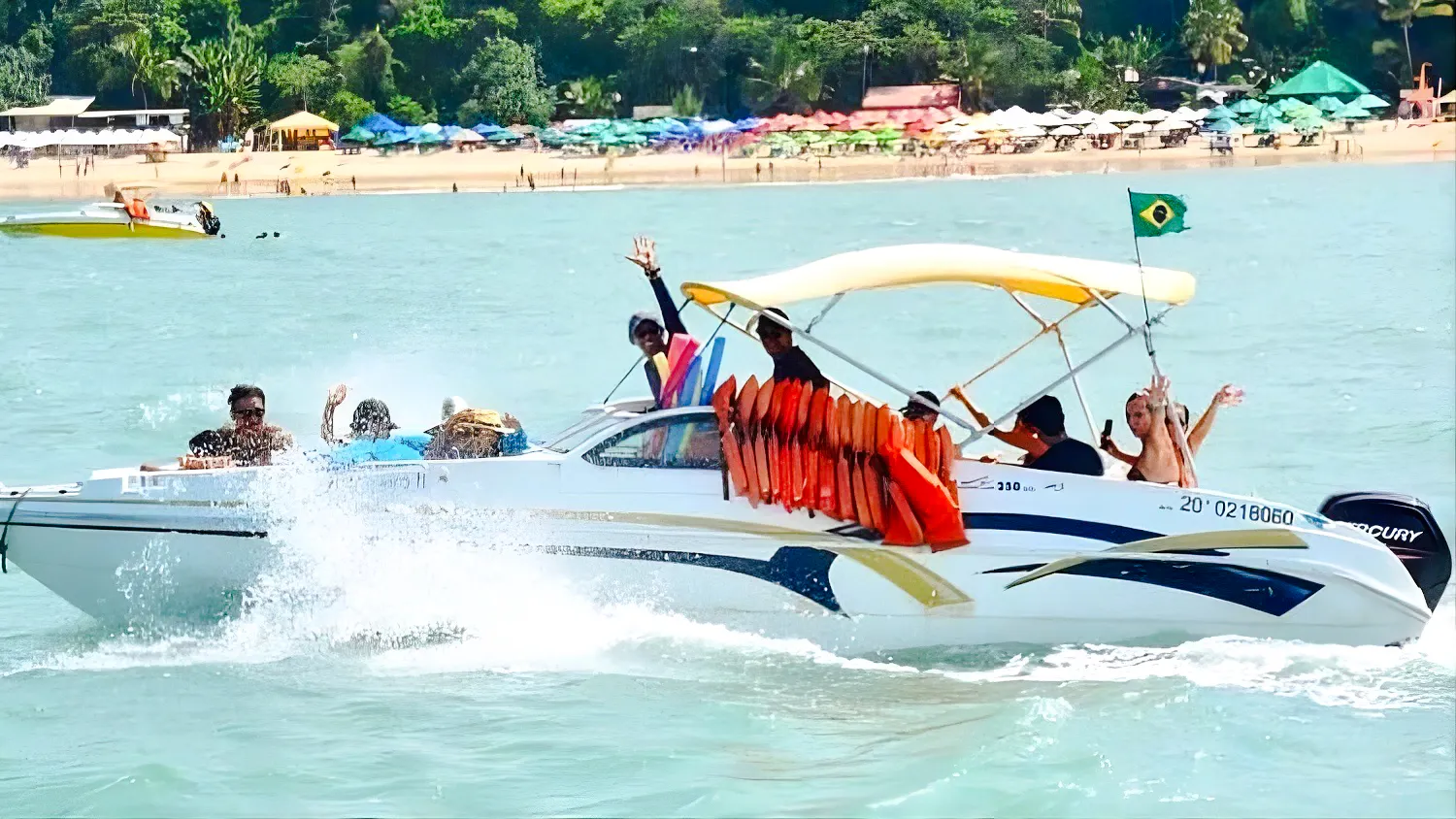 Boat tour with passengers waving near Praia da Pipa beach, Sao Paulo.