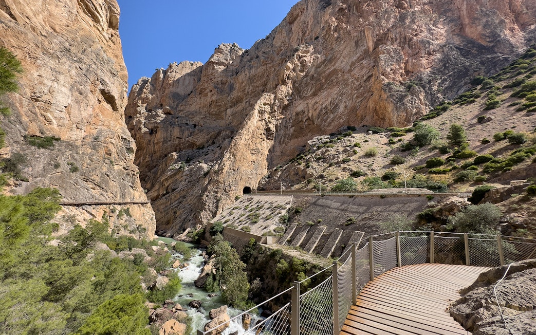 Caminito del Rey walkway through rocky gorge in Málaga, Spain, with river below.