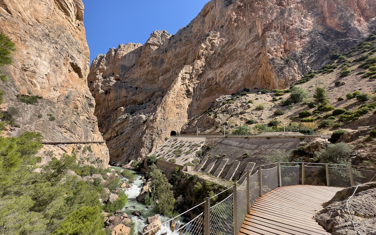 Caminito del Rey walkway through rocky gorge in Málaga, Spain, with river below.