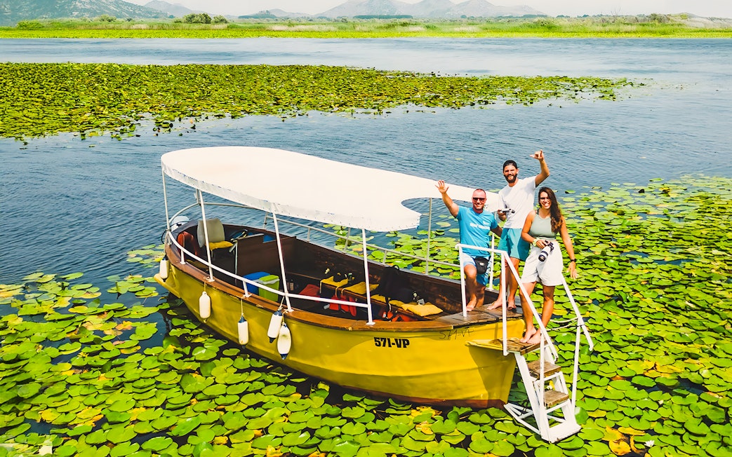 Guests on a wooden boat during a guided sightseeing tour on Lake Skadar.