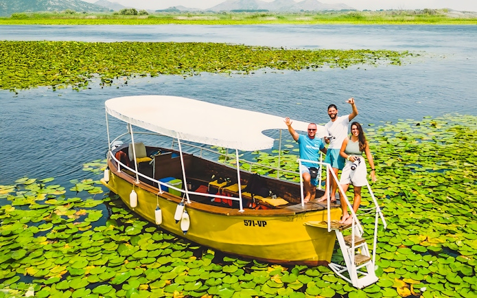 Guests on a wooden boat during a guided sightseeing tour on Lake Skadar.