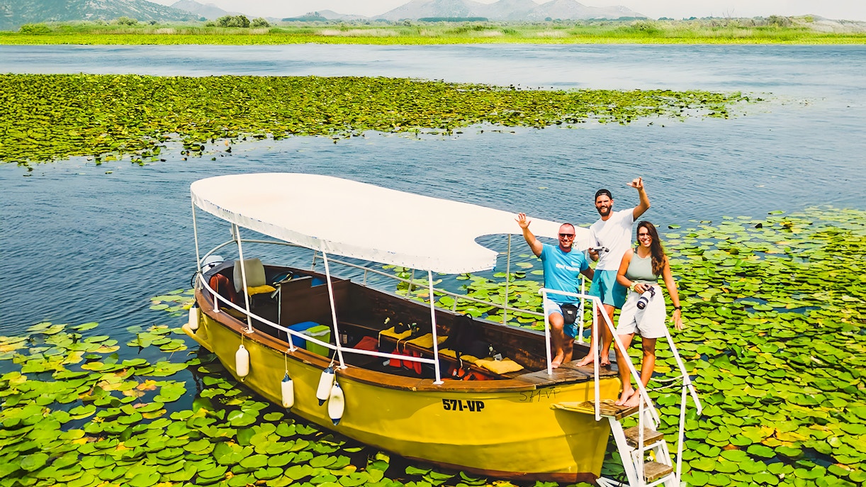 Guests on a wooden boat during a guided sightseeing tour on Lake Skadar.