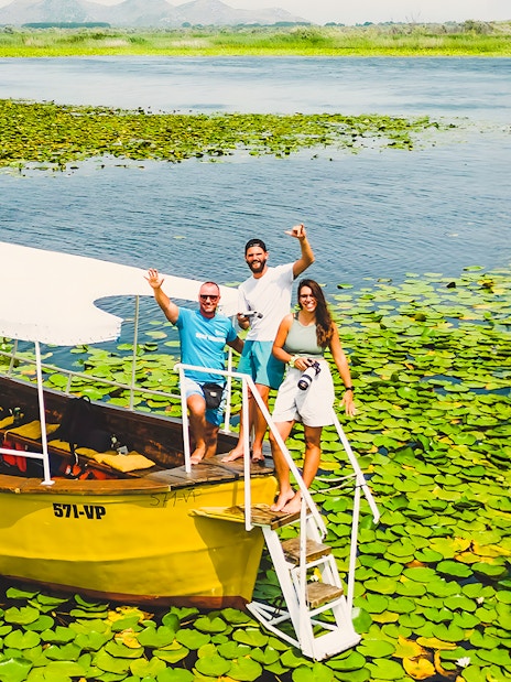 Guests on a wooden boat during a guided sightseeing tour on Lake Skadar.