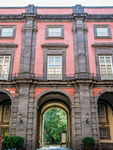 Capodimonte Museum exterior with arched entrance and pink facade in Naples, Italy.