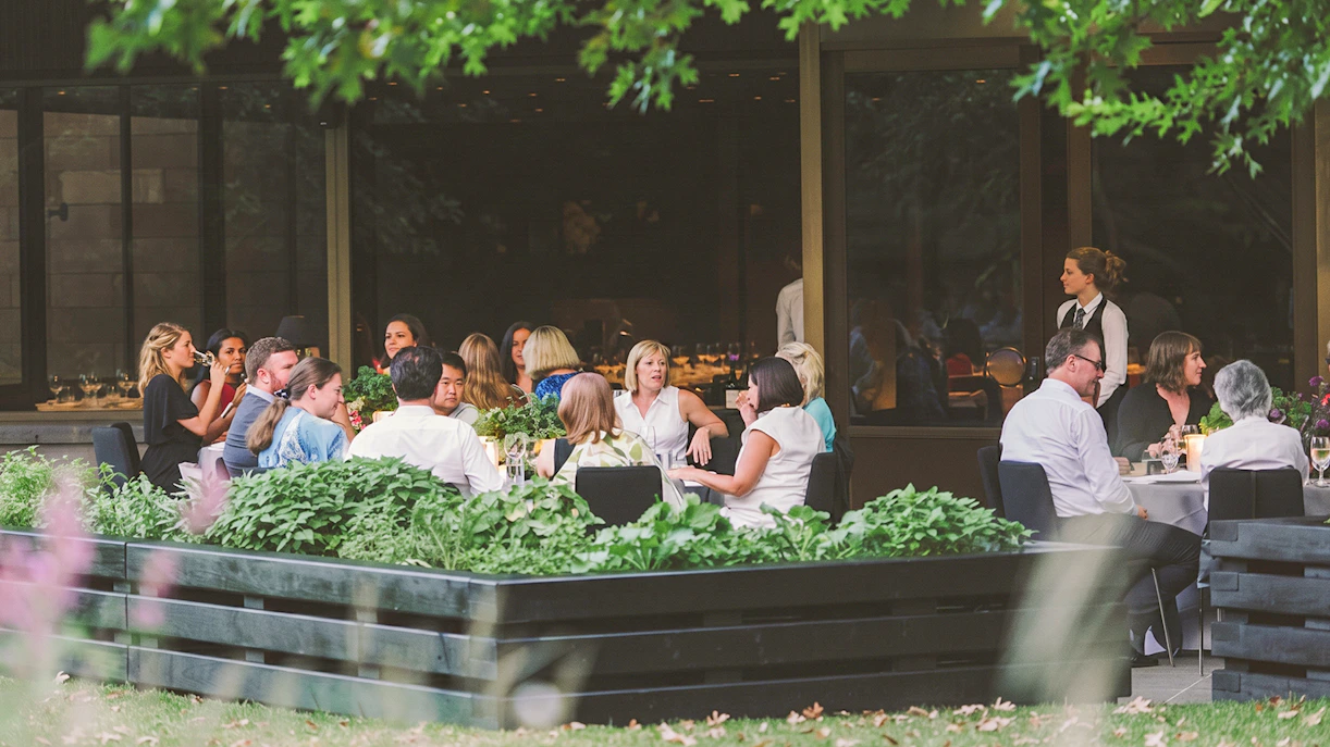 Outdoor dining at NGV garden restaurant with guests seated at tables.