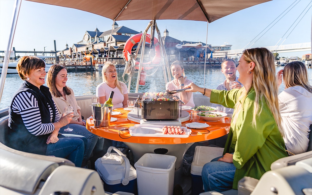 Group enjoying a BBQ on a self-drive boat in Mandurah.